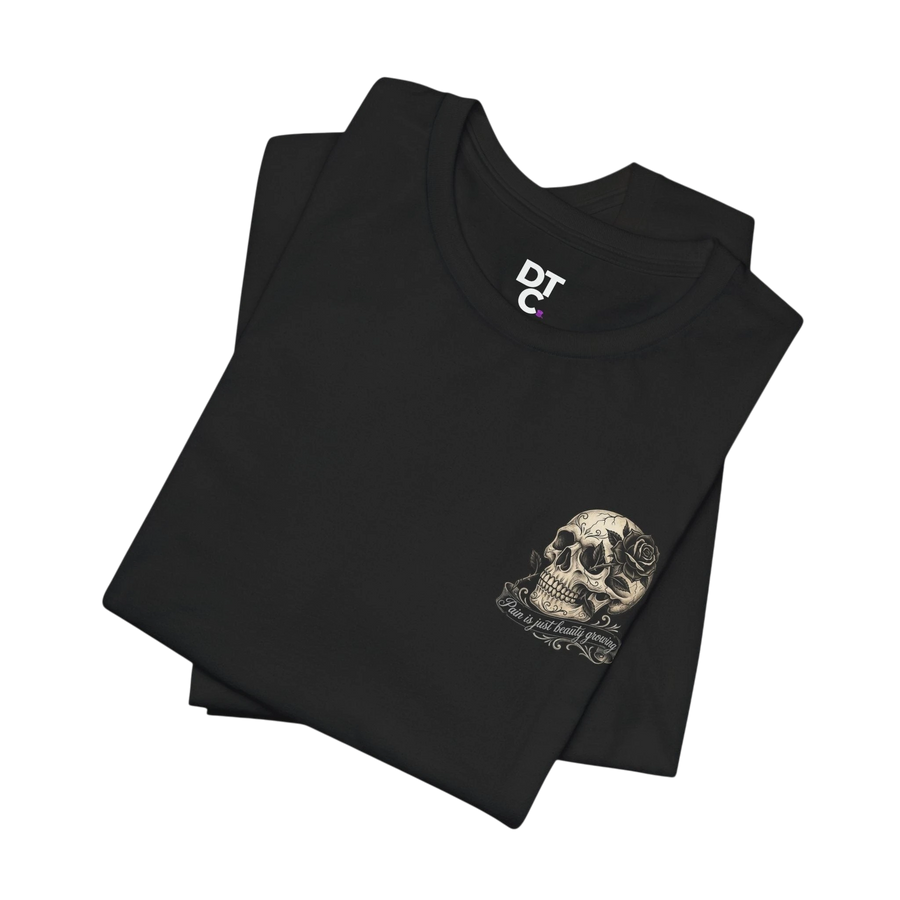 DailyThreadCo black 100% cotton graphic tee with skull and rose artwork on chest. "Pain is just beauty growing" text on banner.