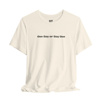 DailyThreadCo. cream 100% cotton crew neck t-shirt with black text 'One Day or Day One' and 'DT' logo on the chest.