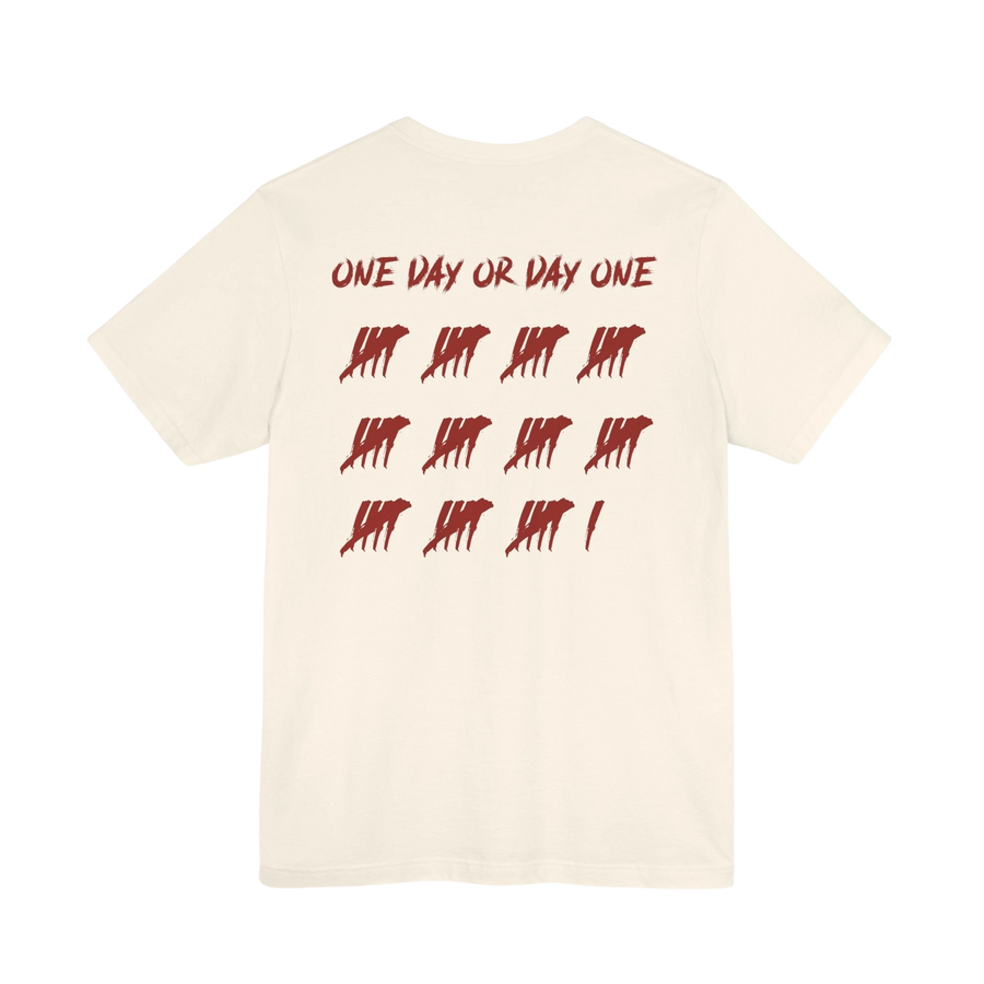 DailyThreadCo. cream cotton t-shirt featuring a red One Day or Day One graphic with tally marks on the back.