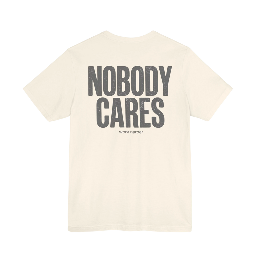 DailyThreadCo. cream cotton graphic t-shirt featuring Nobody Cares text on the back in a distressed grey font.