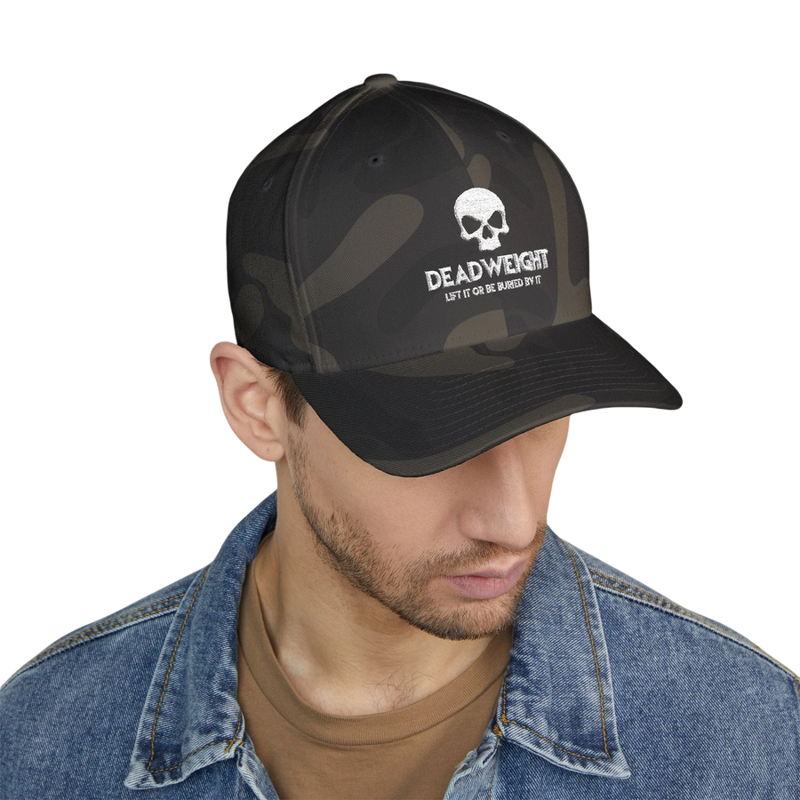 DailyThreadCo. camo Flexfit cap with distressed skull embroidery and Deadweight text on a man in a denim jacket.