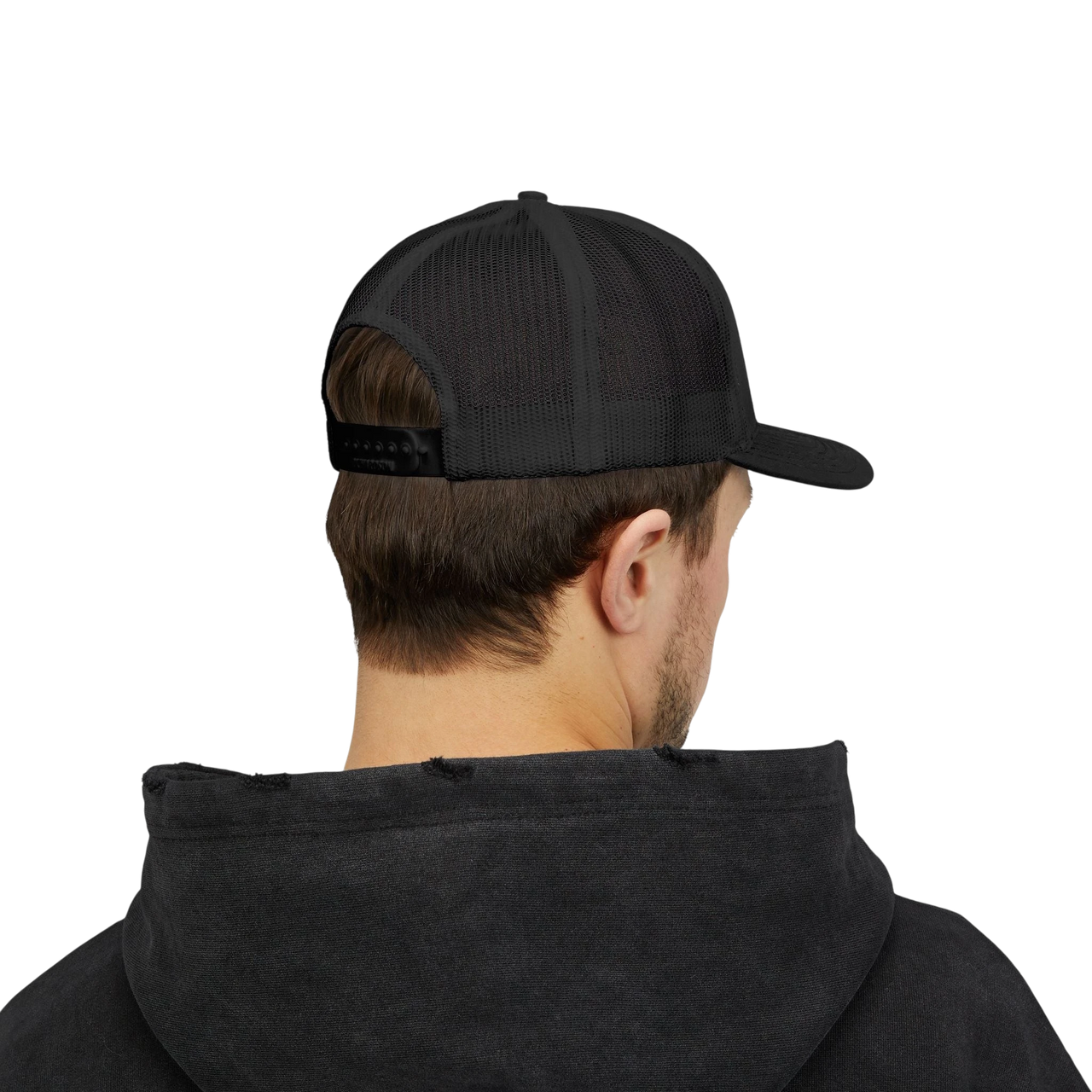 DailyThreadCo. black trucker cap with mesh back and adjustable snapback worn by a man in a black hoodie