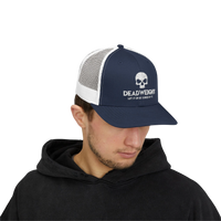 DailyThreadCo. navy blue and white trucker cap with skull logo, worn by a man in a black hoodie.