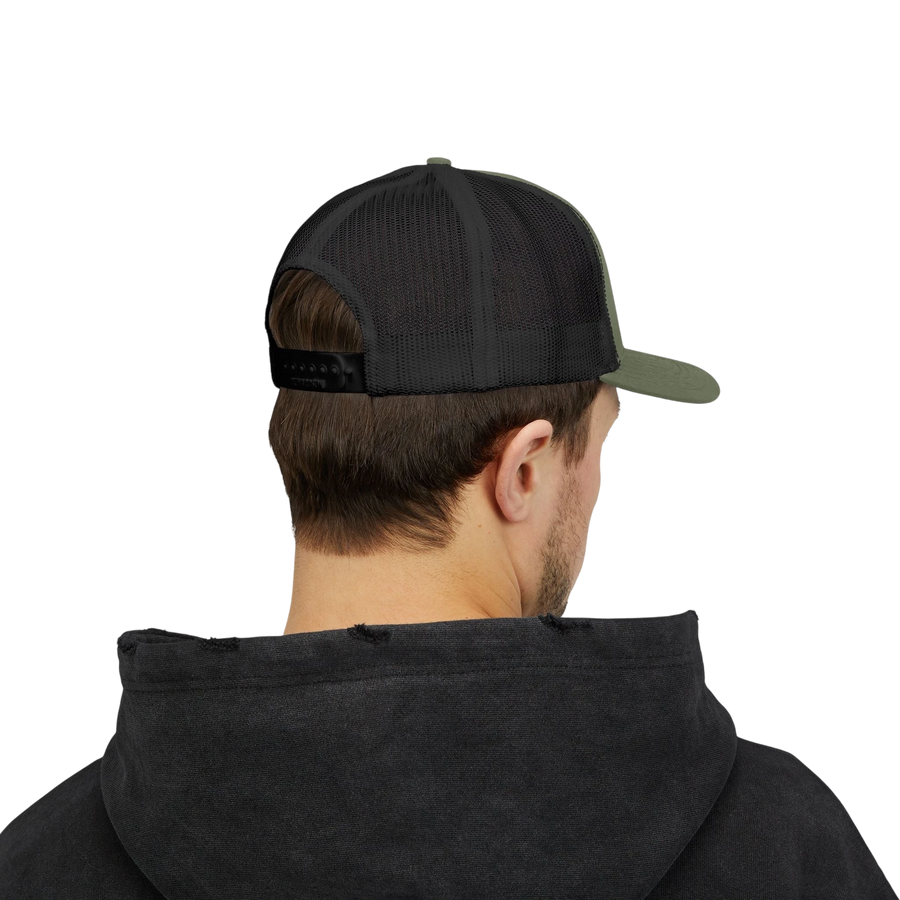 DailyThreadCo. olive green and black trucker cap with mesh back and adjustable snapback worn by a man in a hoodie.