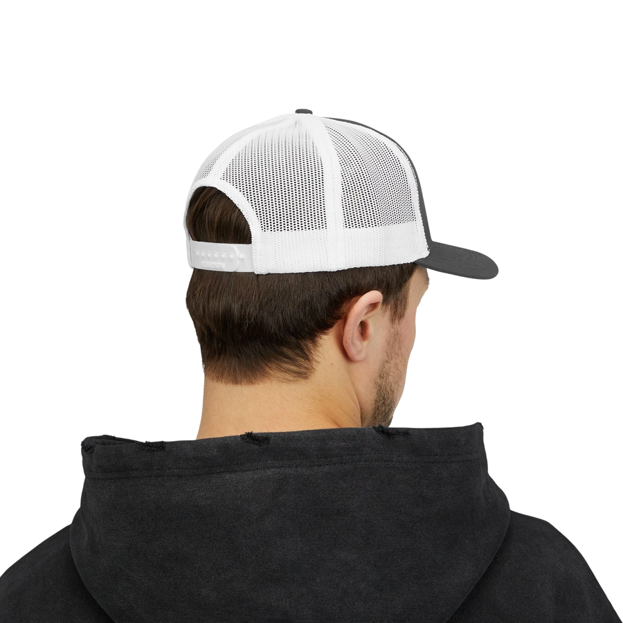DailyThreadCo. Deadweight skull trucker cap with white mesh back and adjustable snapback worn by a man in a hoodie.