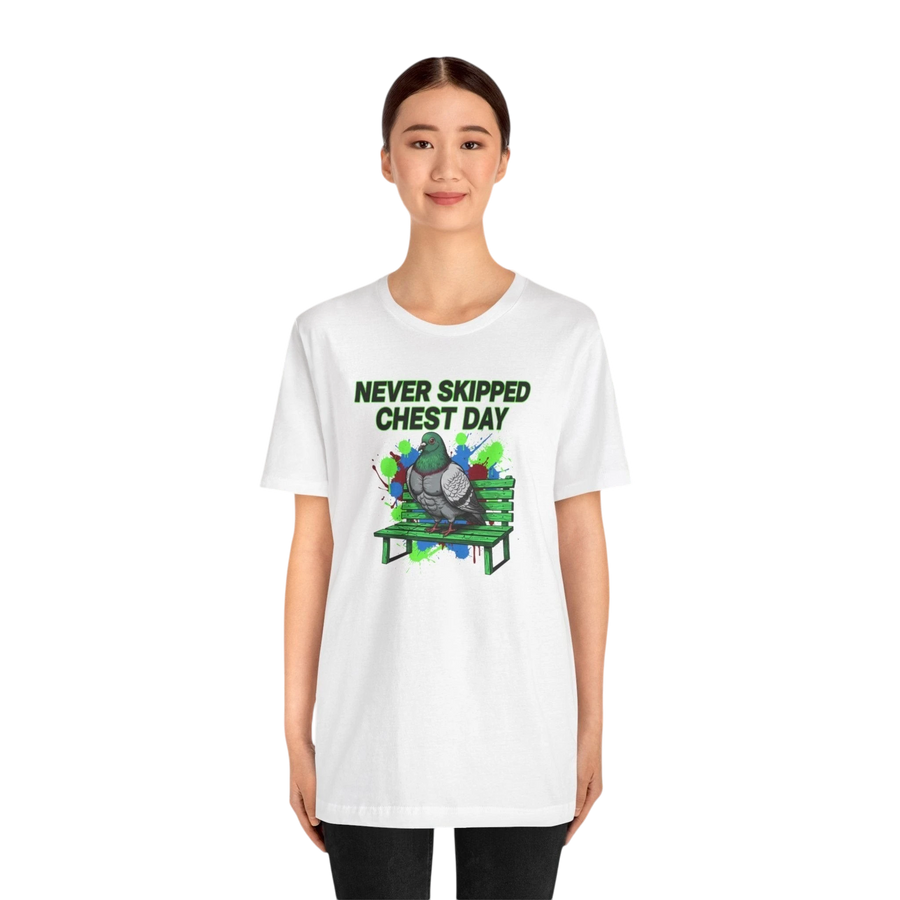 DailyThreadCo. white cotton t-shirt with a graphic of a pigeon on a green bench, text reads "NEVER SKIPPED CHEST DAY".