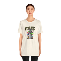 DailyThreadCo. cream 100% cotton t-shirt with a graphic of a raccoon in a trash can, text reads 
