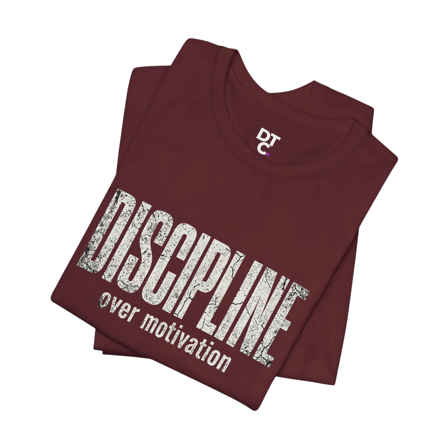 DailyThreadCo. maroon cotton t-shirt with distressed white text reading "DISCIPLINE over motivation".