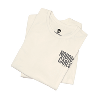 DailyThreadCo. Nobody Cares graphic tee in cream cotton with black text, featuring a crew neck and retail fit.