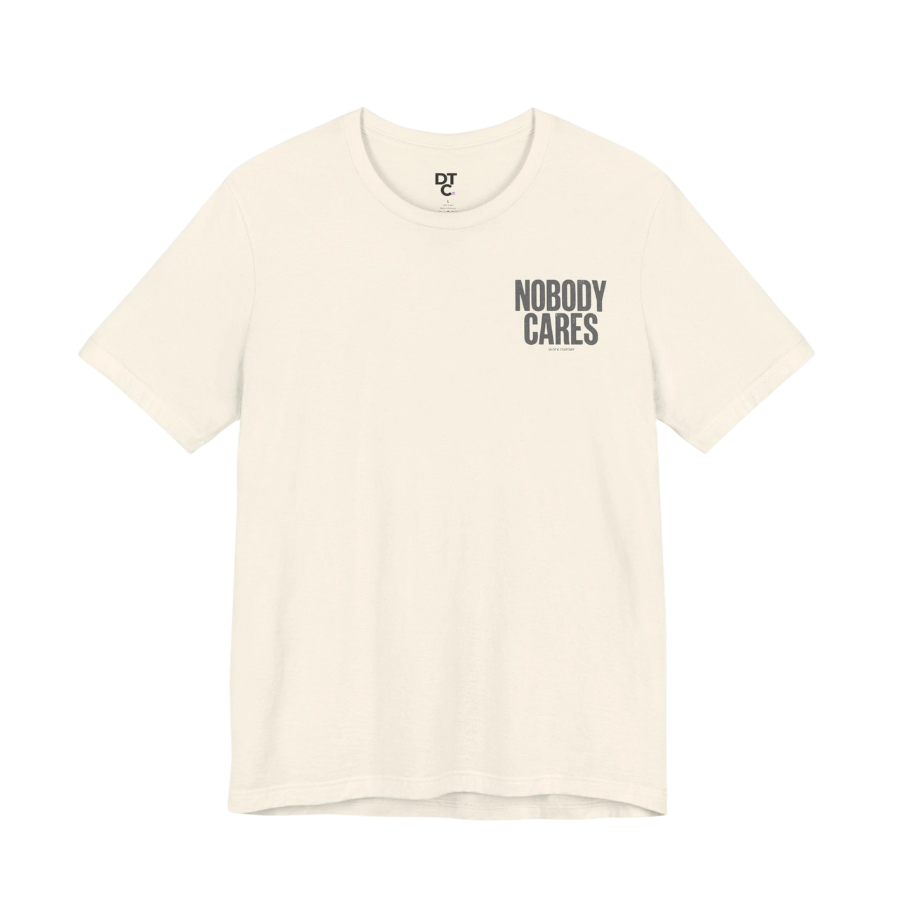 DailyThreadCo. cream 100% cotton graphic tee with "Nobody Cares" text art on the chest.