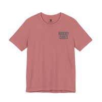 DailyThreadCo. Nobody Cares graphic tee in dusty pink cotton with a crew neckline and minimalist front text design.