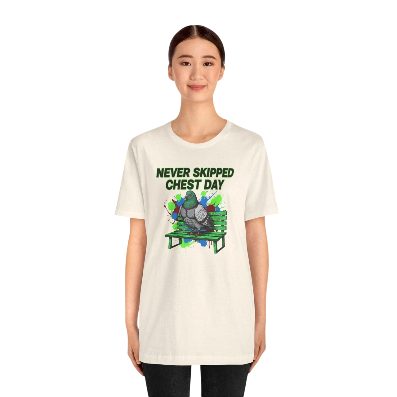 DailyThreadCo. cream cotton t-shirt with a graphic of a pigeon on a green bench, text reads "NEVER SKIPPED CHEST DAY".
