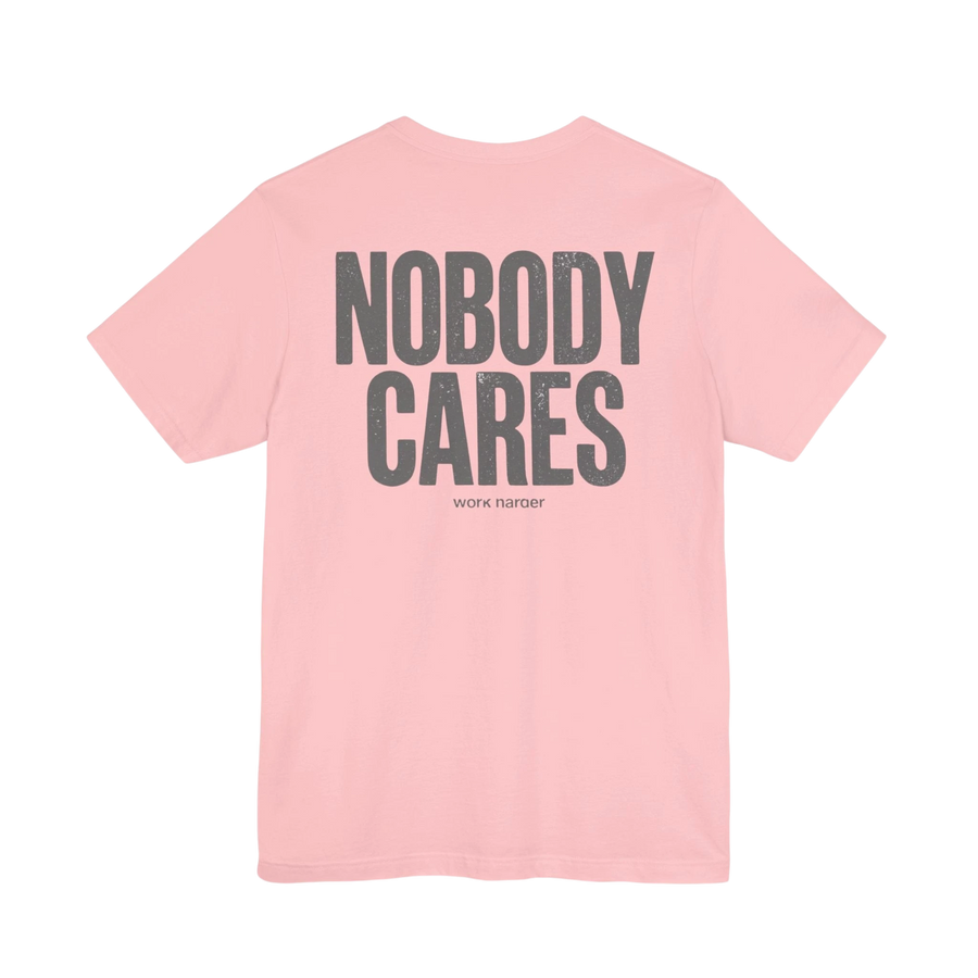 DailyThreadCo. pink cotton graphic t-shirt with Nobody Cares text printed on the back in a distressed grey font.