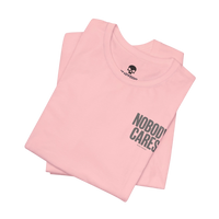 DailyThreadCo. light pink cotton graphic t-shirt featuring Nobody Cares text print, folded with crew neck.