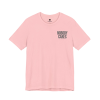 DailyThreadCo. light pink cotton graphic tee featuring the text Nobody Cares on the chest in a clean, modern font.
