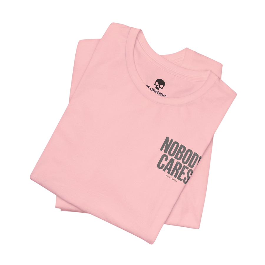 DailyThreadCo. light pink cotton graphic t-shirt featuring Nobody Cares text print, folded with crew neck.