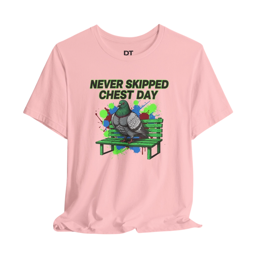 DailyThreadCo. pink cotton t-shirt with a graphic of a muscular pigeon on a green park bench. Text reads "NEVER SKIPPED CHEST DAY".