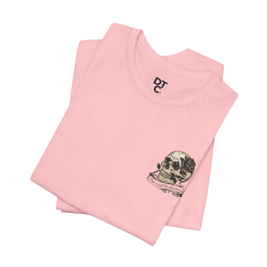 DailyThreadCo. pink 100% cotton graphic tee with skull and rose artwork and "Pain is just beauty growing" text.