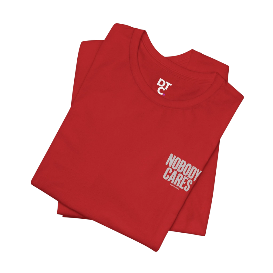 DailyThreadCo. red cotton graphic tee with "Nobody Cares" text and DTC logo on sleeve. Crew neck, short sleeves.