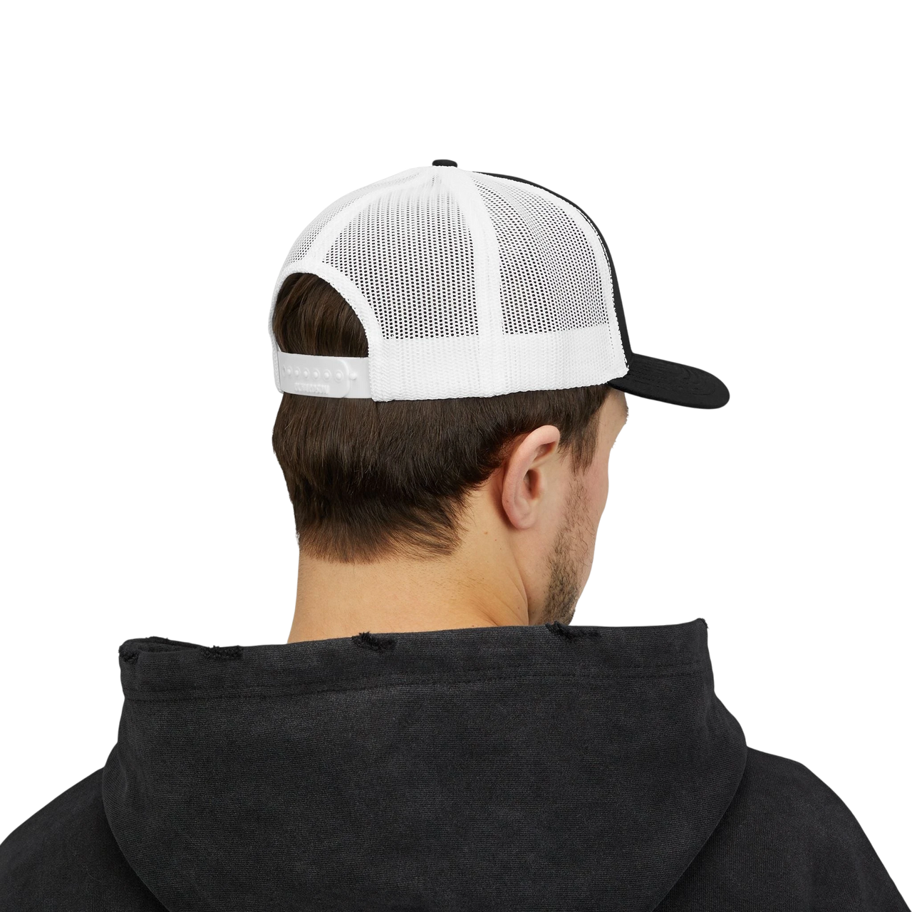DailyThreadCo. black and white trucker cap with breathable mesh back and adjustable snapback worn by a man.