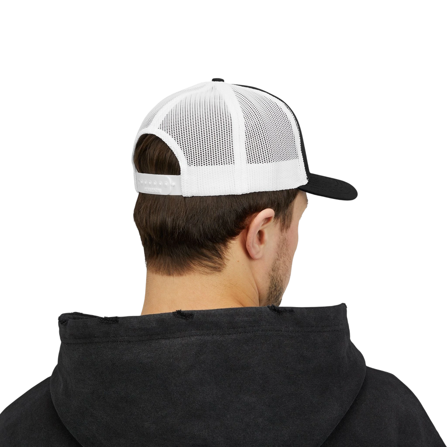 DailyThreadCo. black and white trucker cap with breathable mesh back and adjustable snapback worn by a man.